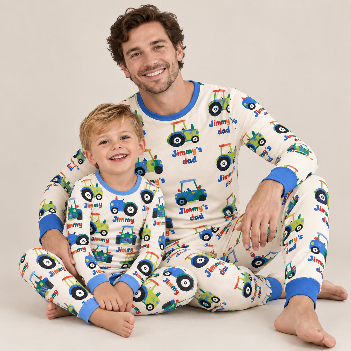Father and son in matching Tractor Crew bamboo pajamas, the boy's printed with his name and dad's reading Jimmy's dad