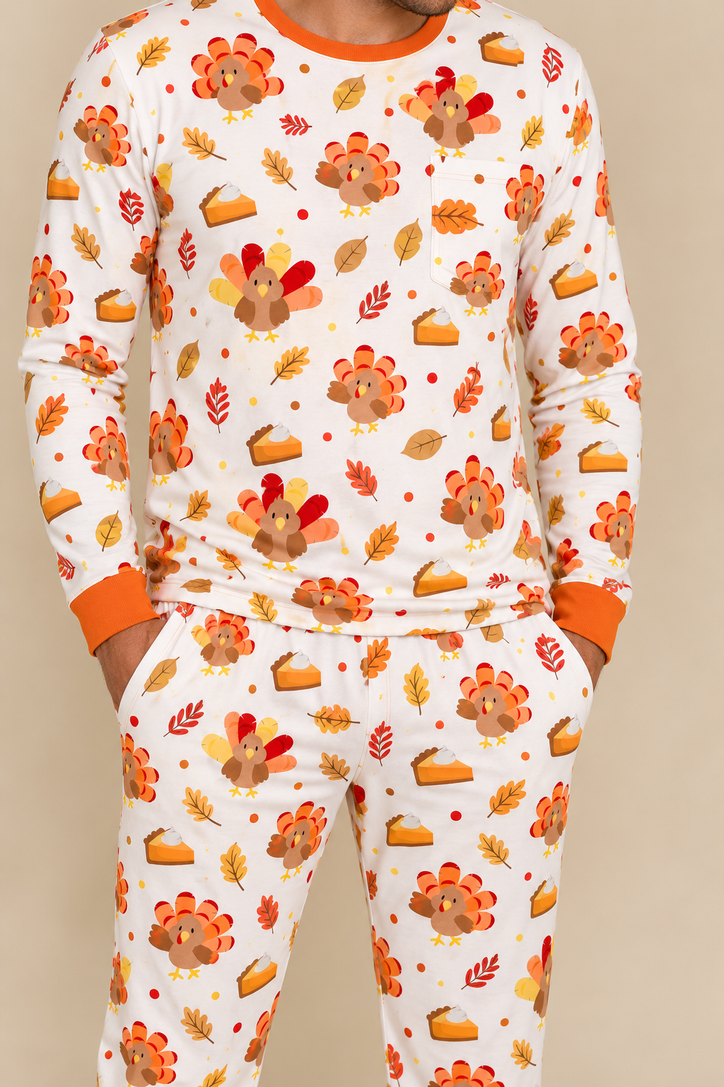Man wearing the Turkey & Pie men's long sleeve bamboo pajama set, cream with turkeys, pumpkin pie and autumn leaves, chest pocket and orange ribbed cuffs