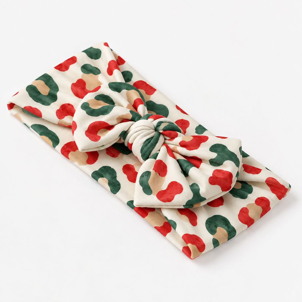 Christmas Leopard bamboo bow headband with a big knotted bow in red, green and gold leopard spots on cream