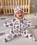 Baby in the Holy Cow I'm One bamboo star suit: hooded star bunting with a grey front zip, grey cow spots and pink Holy Cow I am One lettering