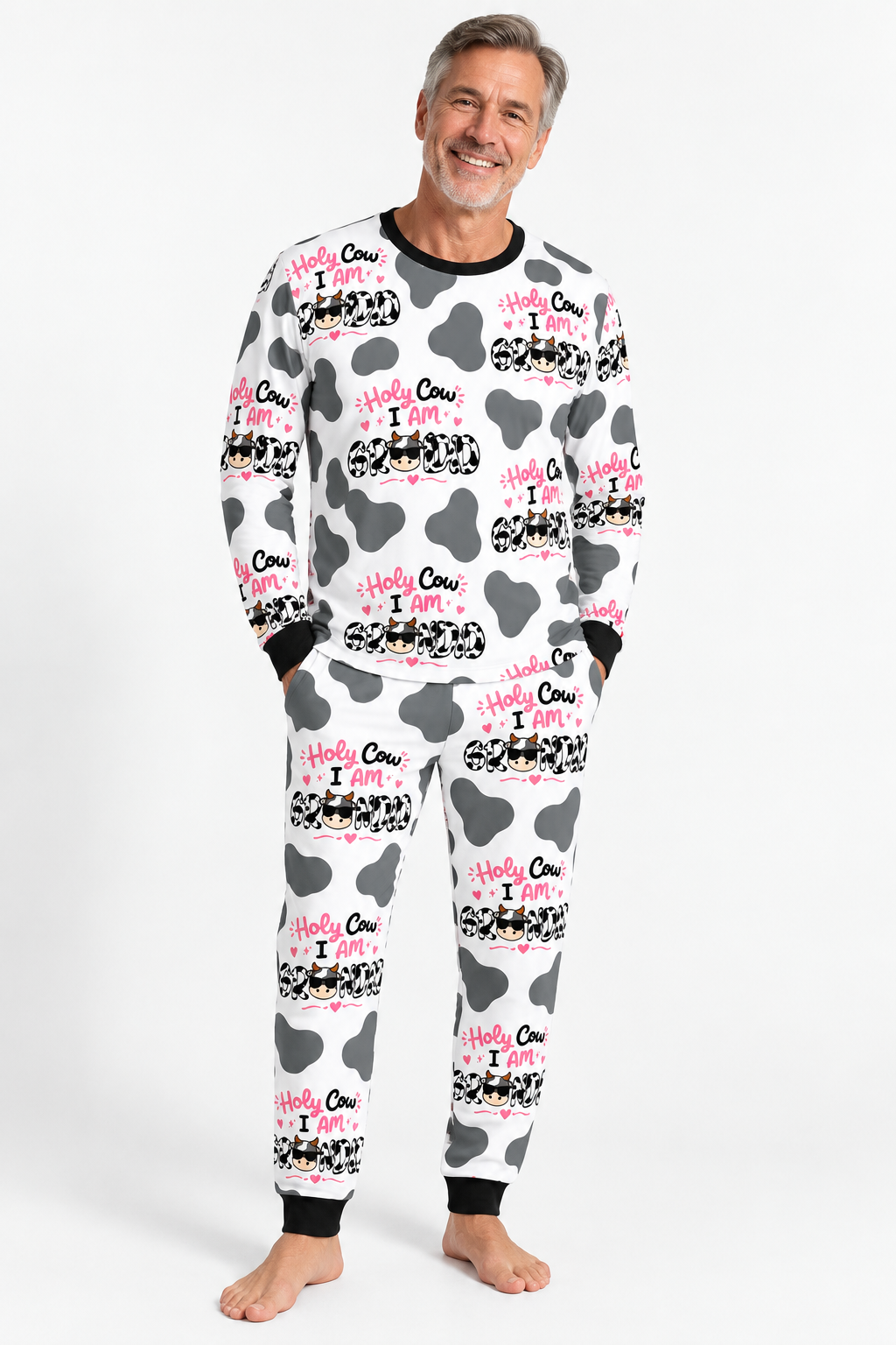 Man wearing Holy Cow I'm Grandad men's bamboo pajamas, white with grey cow spots, pink and black Holy Cow lettering and black cuffs