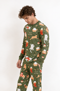 Man wearing the Meowy Christmas men's long sleeve bamboo pajama set, olive green with ginger and white cats in stockings and gift boxes