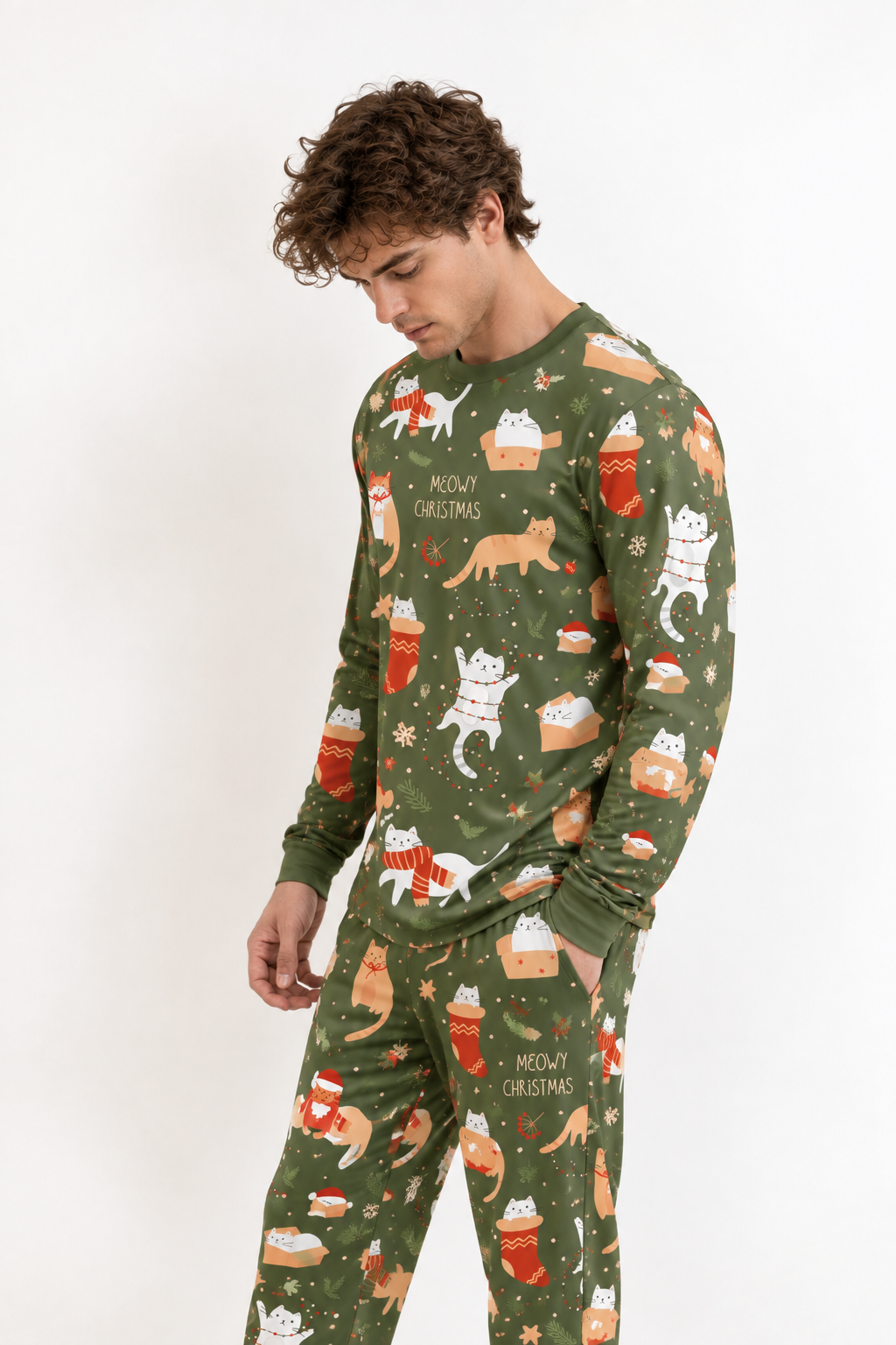 Man wearing the Meowy Christmas men's long sleeve bamboo pajama set, olive green with ginger and white cats in stockings and gift boxes